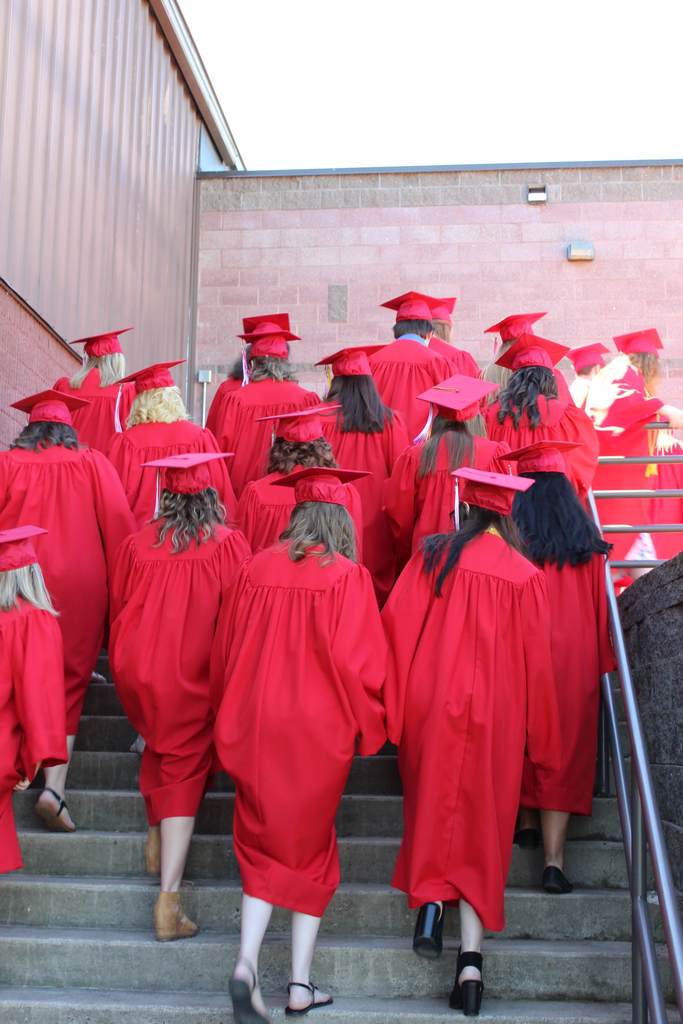 students in graduation caps walking away