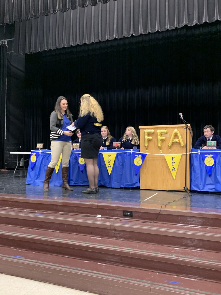 teacher giving ffa student an award