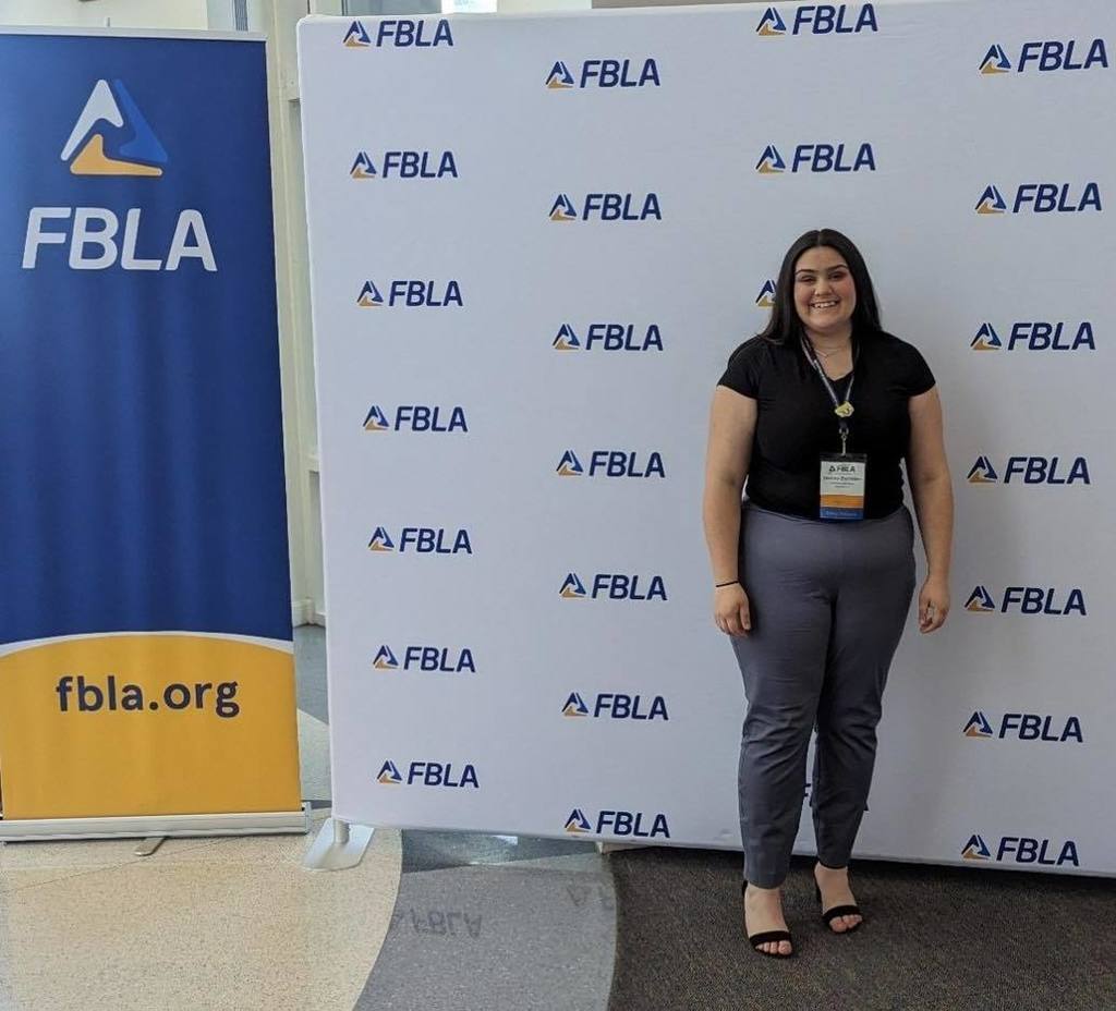 female student standing in front of FBLA sign
